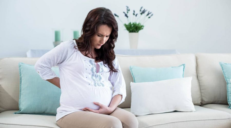 52154448 - pregnant woman with painful back in living room